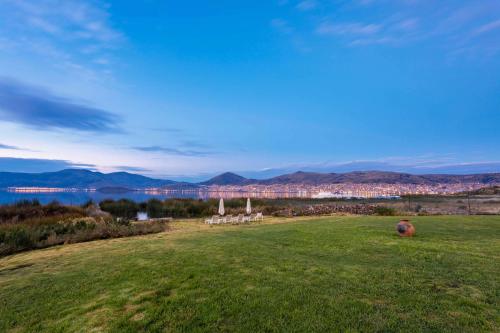 a field with a view of the water and a city at Sonesta Posadas del Inca Puno in Puno
