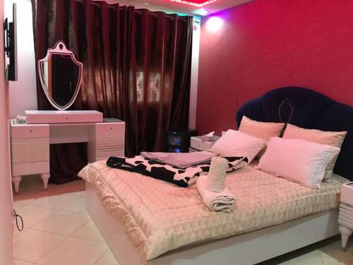a bedroom with a bed with a vanity and a mirror at appartement luxueux à Rabat in Salé