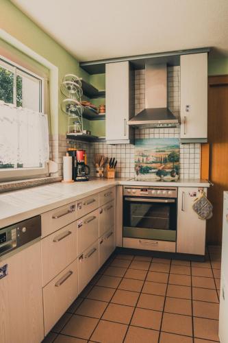 a kitchen with white cabinets and a stove top oven at Gardenia-Altach, 2-4 P, Küche, Garten, Terrasse, Parkplatz, Wifi, Ski Stellplatz in Altach