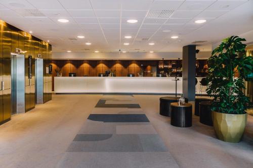 a lobby with a waiting area with a potted plant at Scandic Opalen in Gothenburg