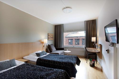 een hotelkamer met 2 bedden en een flatscreen-tv bij Scandic Hallandia in Halmstad