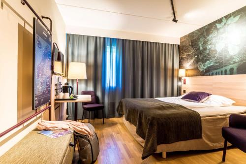 a hotel room with a bed and a flat screen tv at Scandic Kalmar in Kalmar