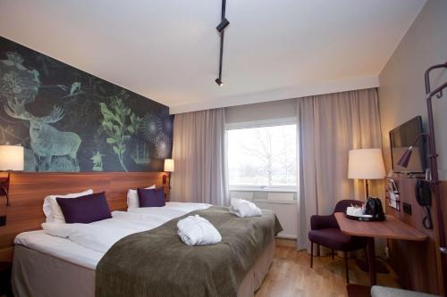 ein Hotelzimmer mit einem großen Bett und einem Schreibtisch in der Unterkunft Scandic Klarälven in Karlstad