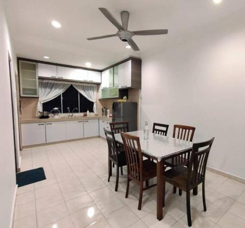 uma cozinha com uma mesa e cadeiras e uma ventoinha de tecto em U&I HOMESTAY KAMPAR em Kampar