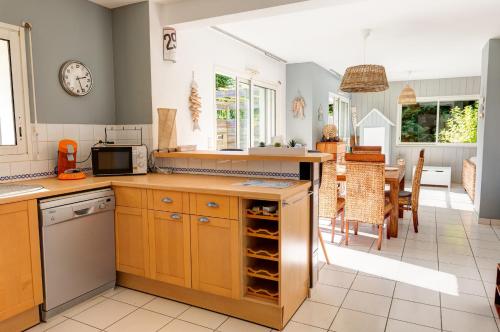 une cuisine avec des armoires en bois et un comptoir dans l'établissement Proche Pointe de la Torche - Maison pour 8, à Plomeur