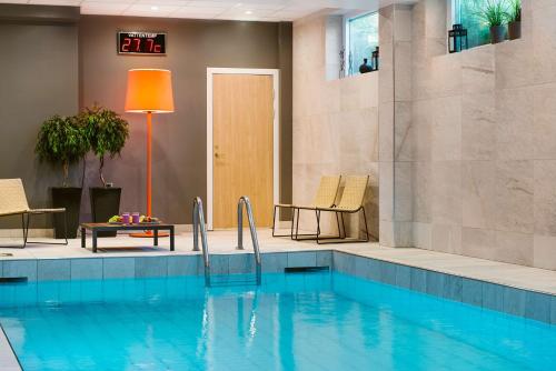 uma piscina num quarto de hotel com piscina em Scandic Kungens Kurva em Estocolmo
