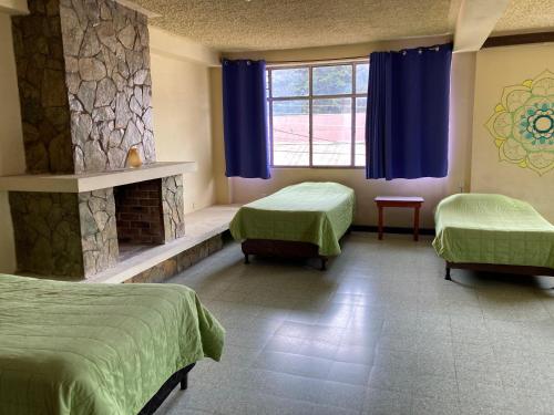 a hospital room with two beds and a fireplace at Kasa Kiwi Hostel & Travel Agency in Quetzaltenango