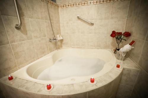 a bath tub with red candles in a bathroom at Hotel Hacienda Plaza de Armas in Puno