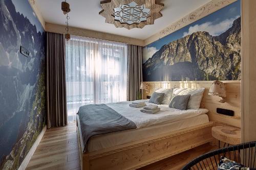a bedroom with a large bed with a mountain mural at Tatra Square Apartments in Zakopane