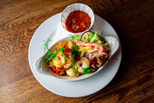 a plate of food with shrimp and sauce on a table at Old Hall Hotel Hope in Hope