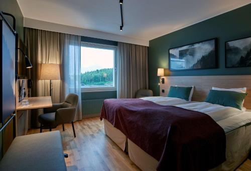 een hotelkamer met een bed, een bureau en een raam bij Scandic Örnsköldsvik in Örnsköldsvik