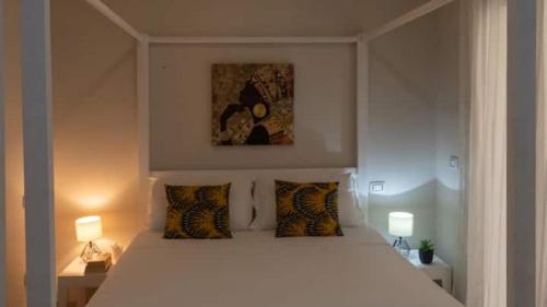 - une chambre avec un grand lit blanc et deux lampes dans l'établissement Casa Meike, à Sal Rei