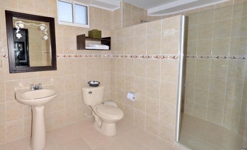 a bathroom with a toilet and a sink and a shower at Hotel Arawak Upar in Valledupar