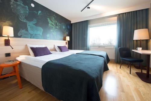 Habitación de hotel con cama grande y escritorio. en Scandic Östersund Syd, en Östersund