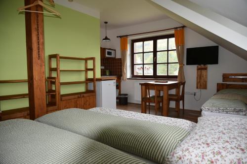 a bedroom with two beds and a kitchen with a window at Chalupa Tomiva in Jeseník