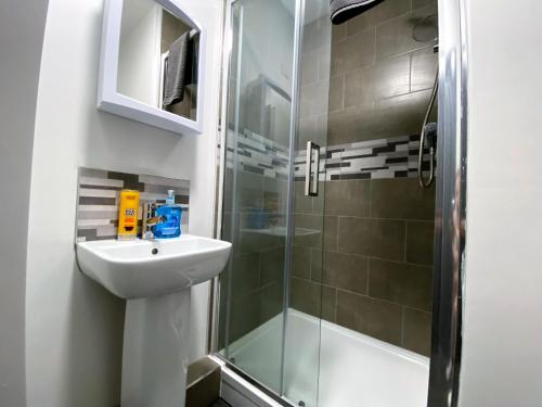 a bathroom with a sink and a shower at StayCrewe Apartments in Crewe