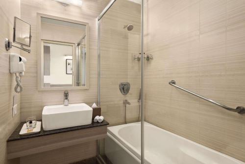 尼梅拉的住宿－尼瑪納戴斯酒店，带浴缸、水槽和淋浴的浴室