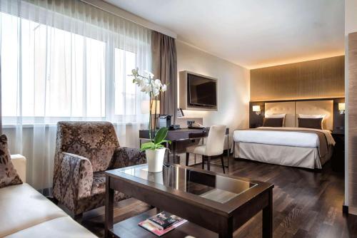 a hotel room with a bed and a desk in a room at Wyndham Grand Salzburg Conference Centre in Salzburg