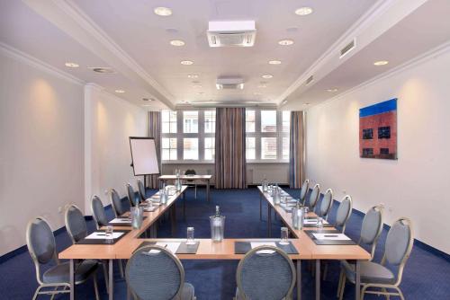 a conference room with long tables and chairs at Wyndham Garden Berlin Mitte in Berlin