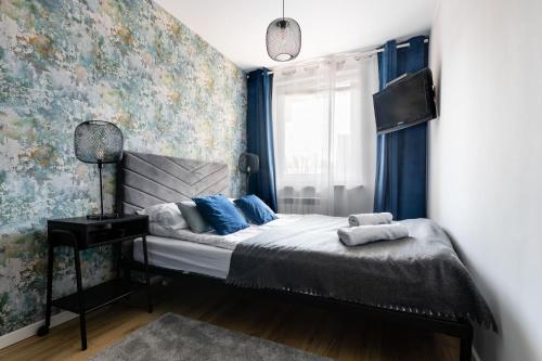 ザコパネにあるApartament Renatek Centrum Zakopaneのベッドルーム1室(青いカーテン、窓付)