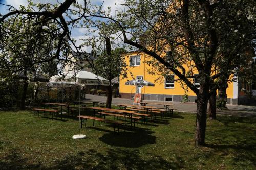 a group of picnic tables in front of a yellow building at Hotel Munzert in Hof