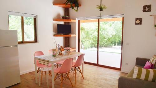 a kitchen and dining room with a table and chairs at Casa Rosa, Quinta Carmo - Alcobaça/Nazaré in Alcobaça