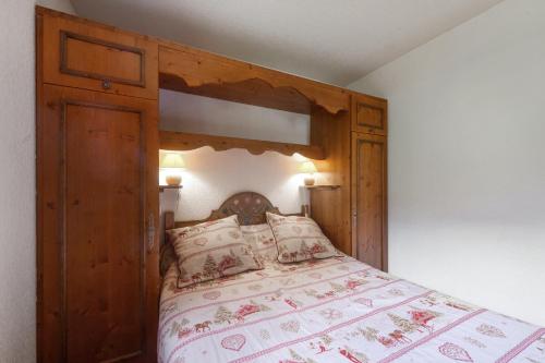 - une chambre avec un lit en bois et une tête de lit en bois dans l'établissement Appartement chaleureux à Les Houches 29 m² avec piscine partagée, aux Houches