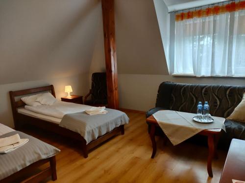 Habitación de hotel con 2 camas y sofá en Dworek Zawadzkich, en Kruszyn