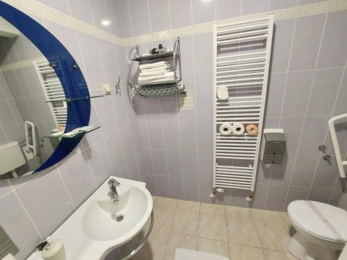 a bathroom with a sink and a toilet and a mirror at Hotel Villa Valpovo in Valpovo