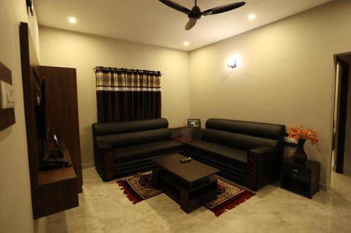 a living room with a couch and a table at RR Holidays in Kodaikānāl