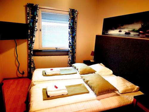 - une chambre avec 2 lits, des serviettes et une fenêtre dans l'établissement Nätra Motell, à Bjästa