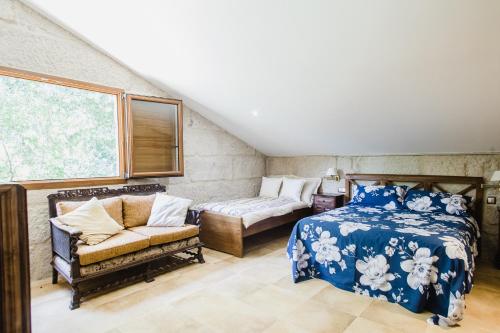 Un dormitorio con una cama y un sofá y una ventana. en Villa Casa de Campo Los Carballos, en Tomiño