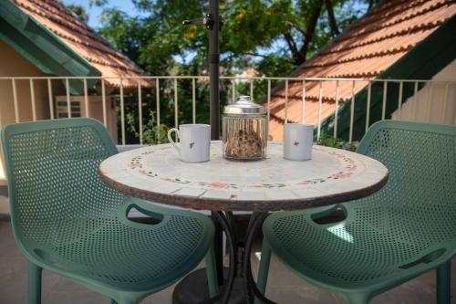 a table with two chairs and a table with two coffee cups at Amanda's place Central Modern spacious family APT in Zikhron Ya‘aqov
