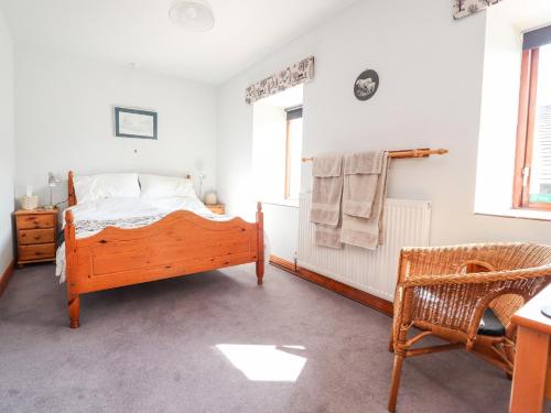 a bedroom with a bed and a chair at Granary in Clitheroe