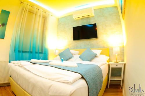 sypialnia z dwoma łóżkami i telewizorem na ścianie w obiekcie Pál Villa - Premium Apartments - Kecskemét w mieście Kecskemét