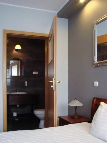 a bedroom with a bed and a bathroom with a toilet at Dworek Zawadzkich in Kruszyn