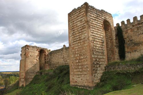 una vieja pared de ladrillo con dos arcos en una colina en Casa Rural Placida, en Escalona