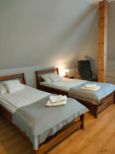 a room with two beds with towels on them at Dworek Zawadzkich in Kruszyn