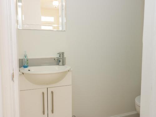 a white bathroom with a sink and a mirror at 6 Coltbridge Gardens in Edinburgh