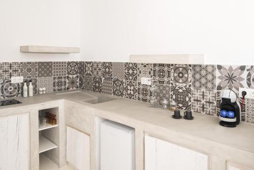 a kitchen with black and white tiles on the wall at Andria's suites in Chrissi Akti