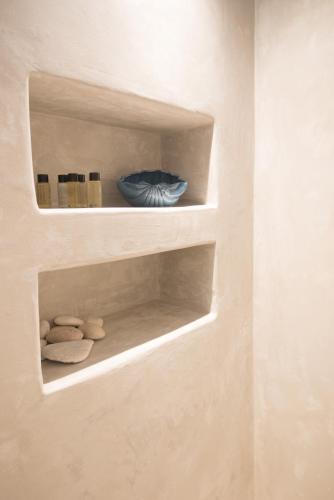 a shelf with a blue bowl and rocks on it at Andria's suites in Chrissi Akti
