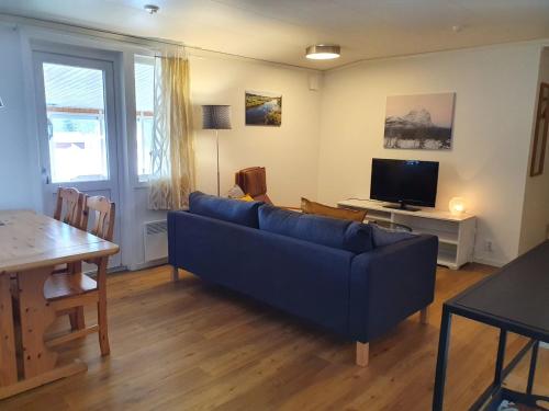 sala de estar con sofá azul y TV en Kultsjögården-Saxnäs-Marsfjällen 9, en Saxnäs