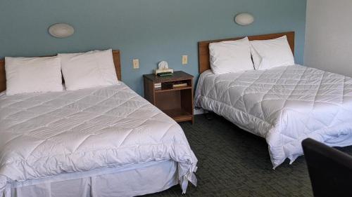 ein Hotelzimmer mit 2 Betten und einem Nachttisch in der Unterkunft Valois Motel & Restaurant in Mattawa