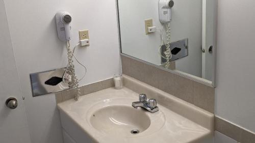 y baño con lavabo y espejo. en Valois Motel & Restaurant en Mattawa