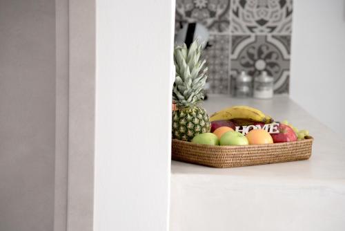 a basket of fruit sitting on a counter with a pineapple at Andria's suites in Chrissi Akti