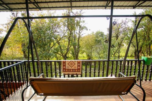 a hammock on a screened in porch with a bench at Guest House Iaraji in Tʼianetʼi