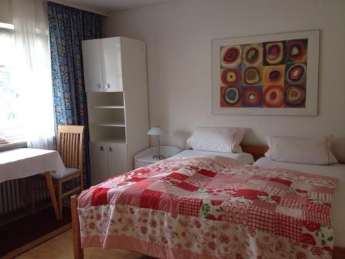 Schlafzimmer mit einem Bett mit einer roten und weißen Decke in der Unterkunft Gästehaus Stapf in Oberaurach