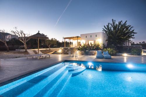 a swimming pool in front of a house at Andria's suites in Chrissi Akti