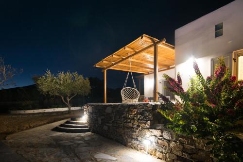 a building with a porch at night with a swing at Andria's suites in Chrissi Akti