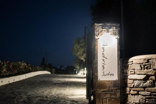 a gate with a sign on the side of a road at night at Andria's suites in Chrissi Akti